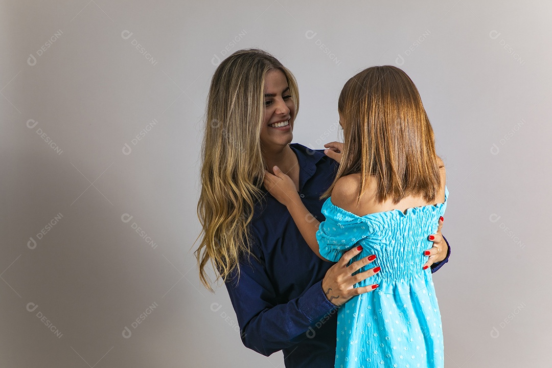 Belo retrato de mãe e filha sorridente se abraçando sobre fundo isolado