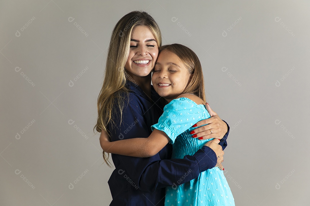Belo retrato de mãe e filha sorridente se abraçando sobre fundo isolado