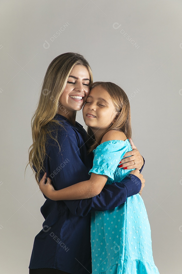 Belo retrato de mãe e filha sorridente se abraçando sobre fundo isolado