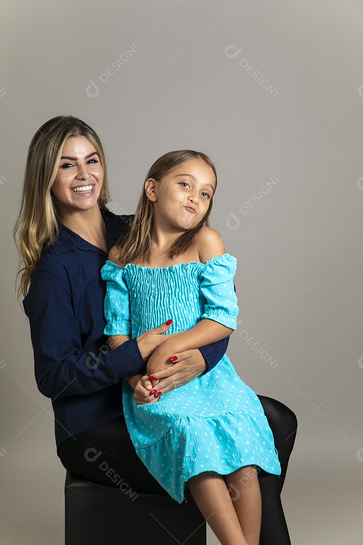 Belo retrato de mãe e filha sorridente fazendo pose sobre fundo isolado