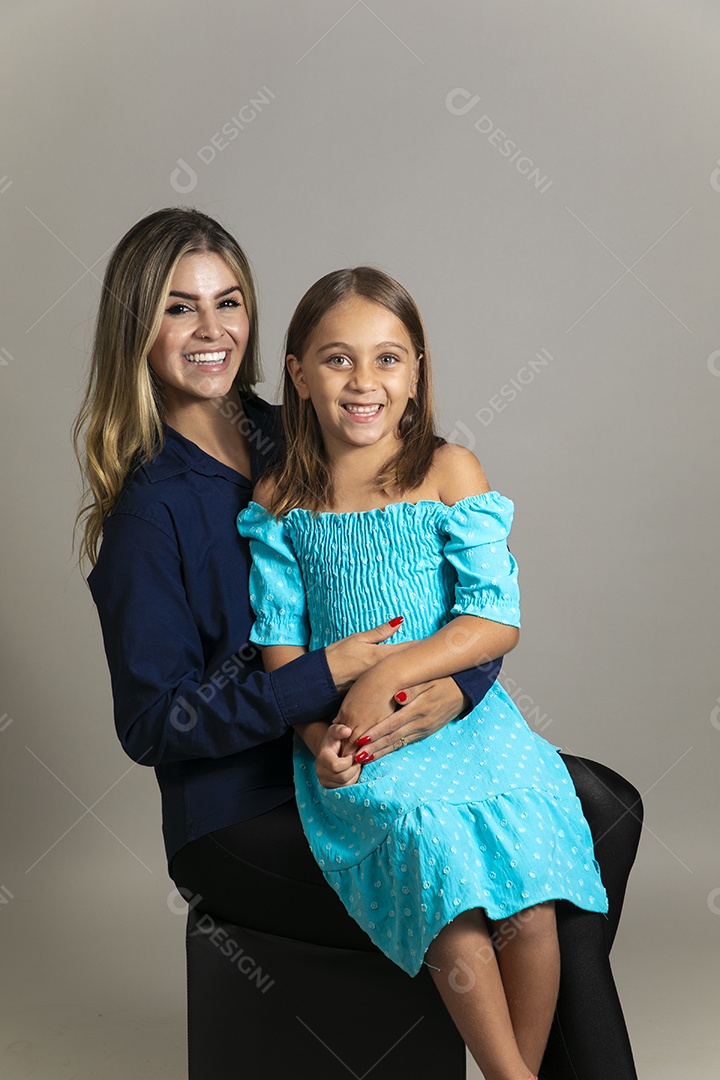 Belo retrato de mãe e filha sorridente fazendo pose sobre fundo isolado