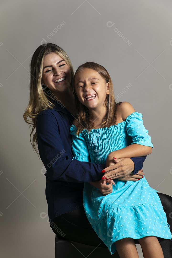 Belo retrato de mãe e filha sorridente se abraçando sobre fundo isolado