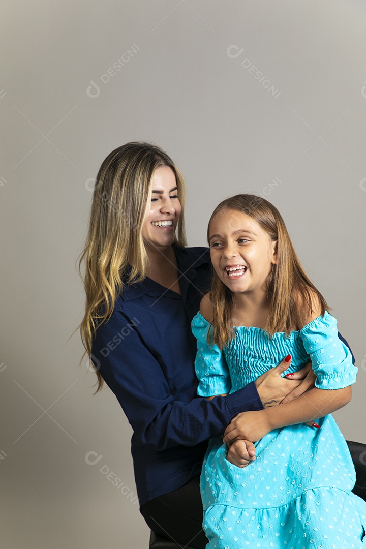 Belo retrato de mãe e filha sorridente se abraçando sobre fundo isolado