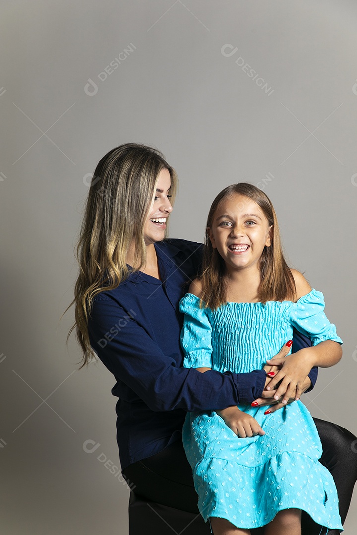 Belo retrato de mãe e filha sorridente se abraçando sobre fundo isolado