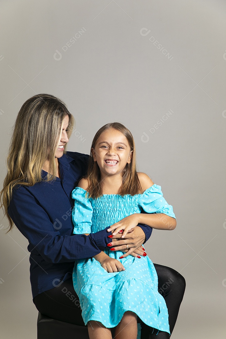 Belo retrato de mãe e filha sorridente se abraçando sobre fundo isolado