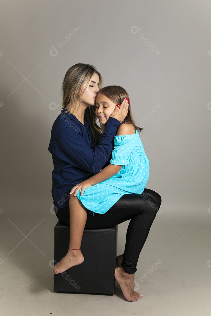 Belo retrato de mãe e filha sorridente sentada ao colo sobre fundo isolado
