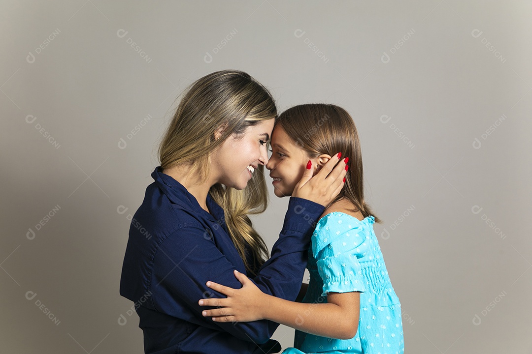 Bela mãe e filha se encarando com grande sorriso no rosto sobre fundo isolado