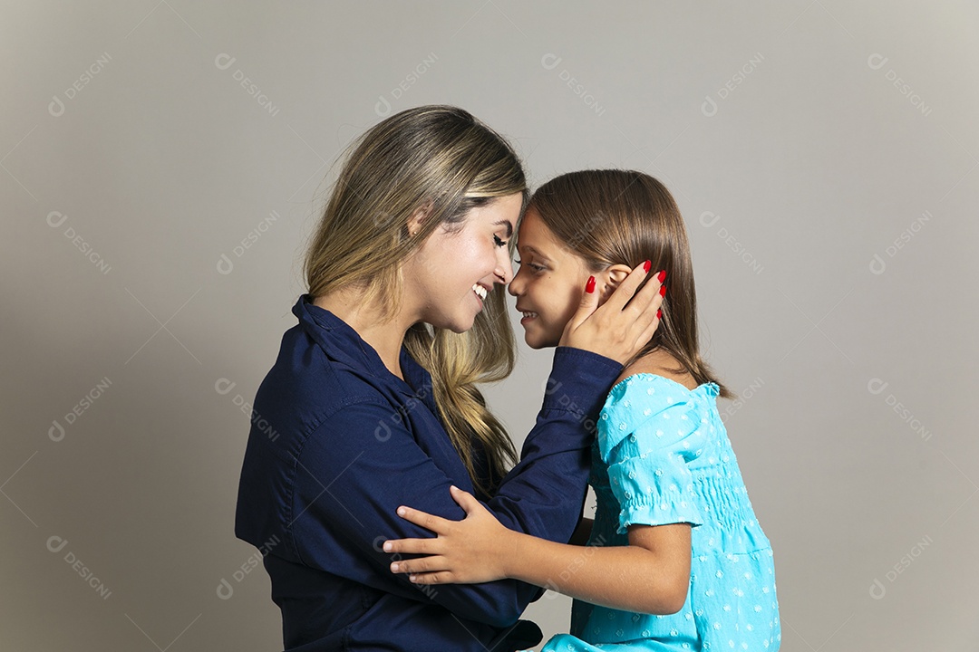 Bela mãe e filha se encarando com grande sorriso no rosto sobre fundo isolado