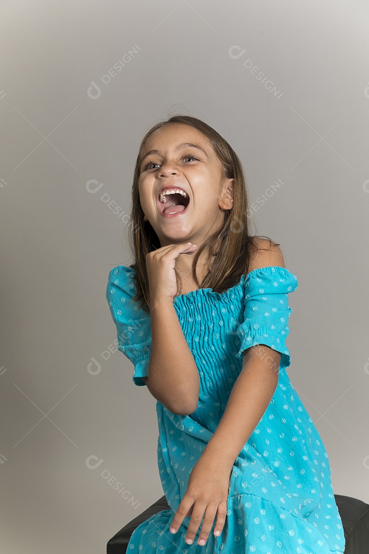 Linda garotinha usando vestido longo azul fazendo gesto de grito sobre fundo isolado