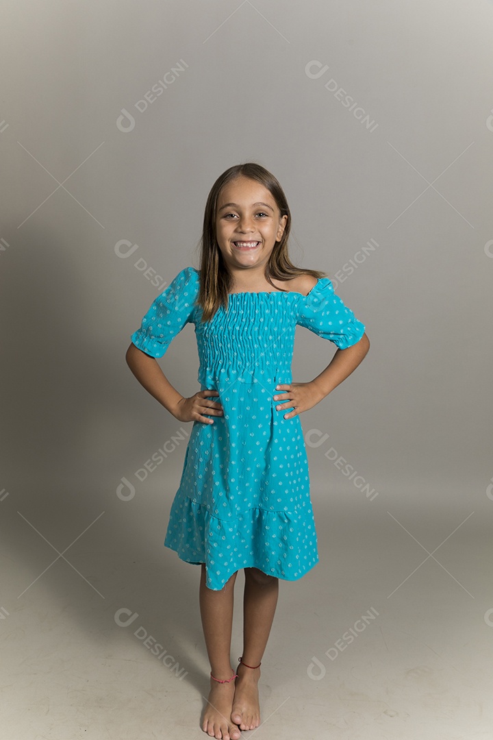 Linda garotinha usando vestido longo azul fazendo pose sobre fundo isolado