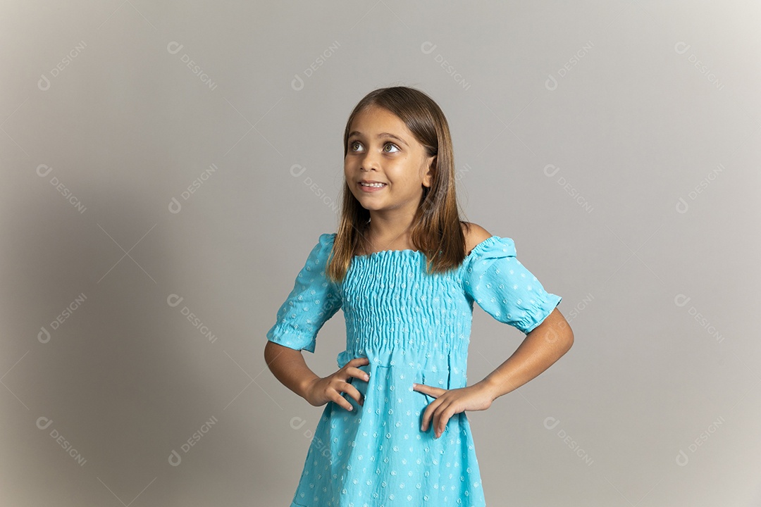 Linda garotinha usando vestido longo azul fazendo pose sobre fundo isolado