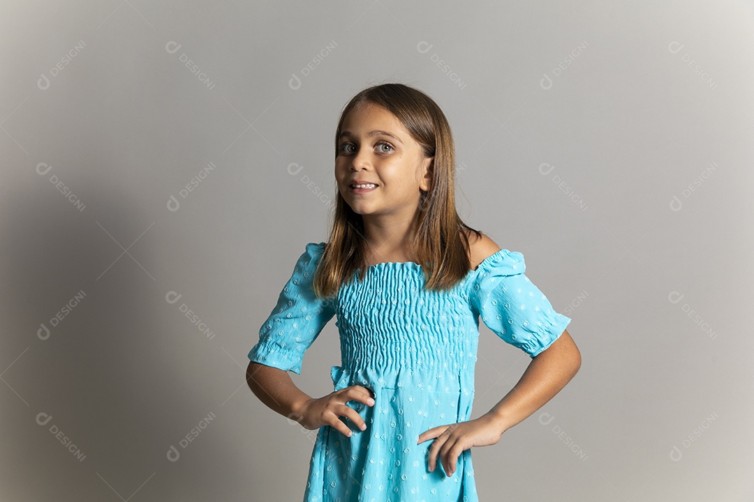 Linda garotinha usando vestido longo azul fazendo pose sobre fundo isolado