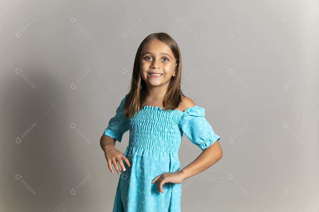 Linda garotinha usando vestido longo azul fazendo pose sobre fundo isolado