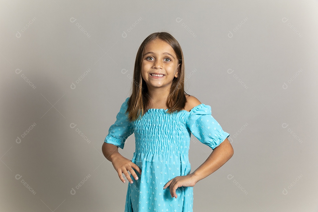 Linda garotinha usando vestido longo azul fazendo pose sobre fundo isolado