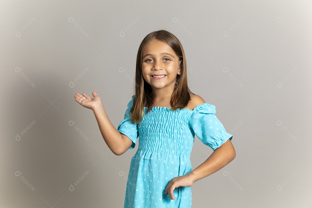 Linda garotinha usando vestido longo azul fazendo pose sobre fundo isolado