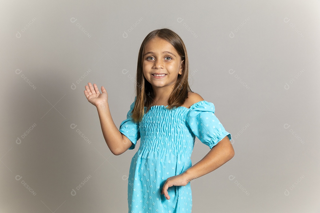 Linda garotinha usando vestido longo azul fazendo pose sobre fundo isolado