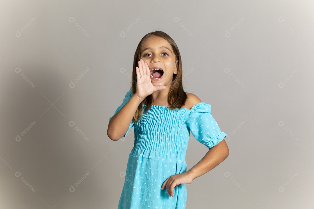 Linda garotinha usando vestido longo azul fazendo pose sobre fundo isolado