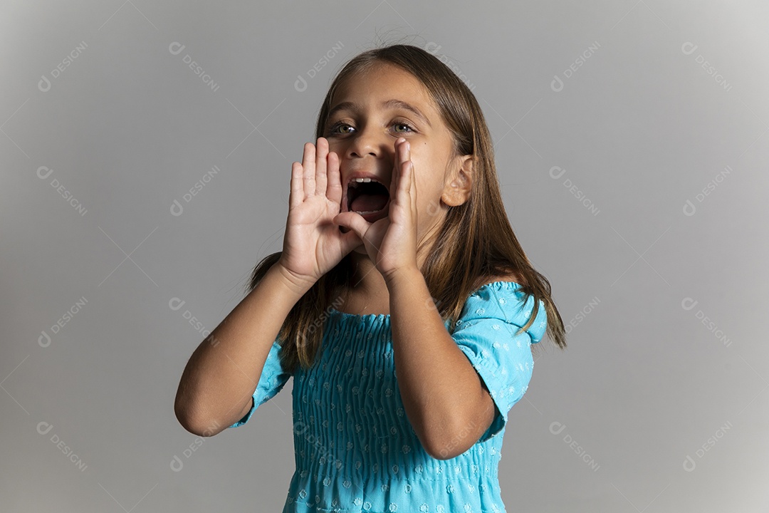 Linda garotinha usando vestido longo azul fazendo gesto de grito sobre fundo isolado