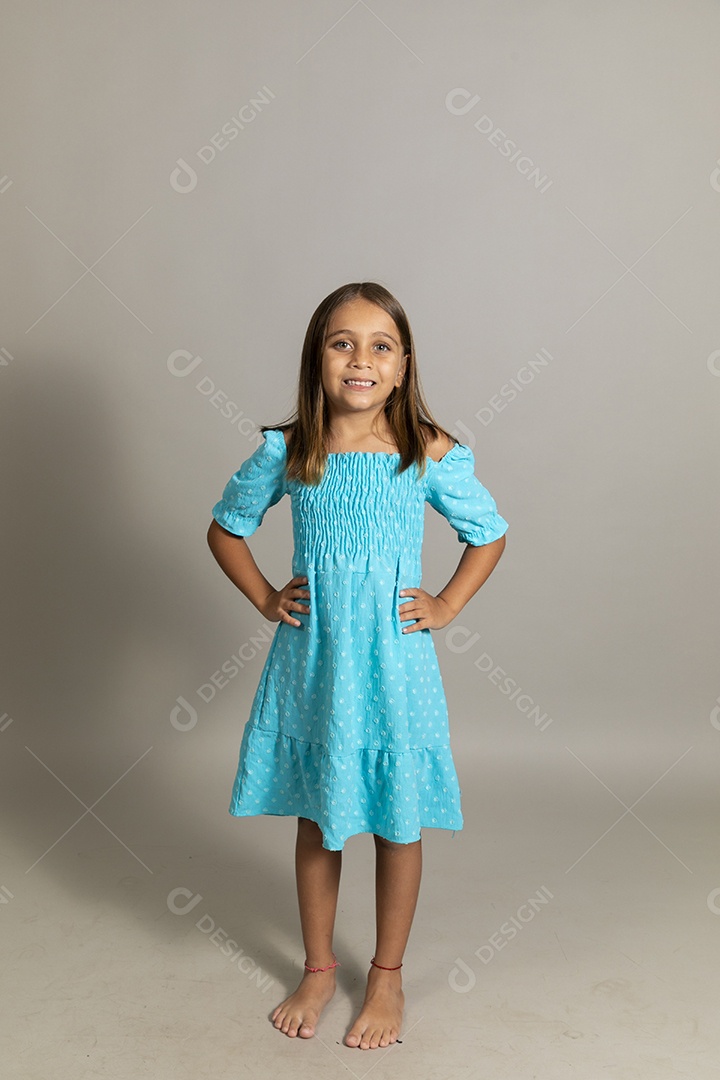 Linda garotinha usando vestido longo azul fazendo pose sobre fundo isolado