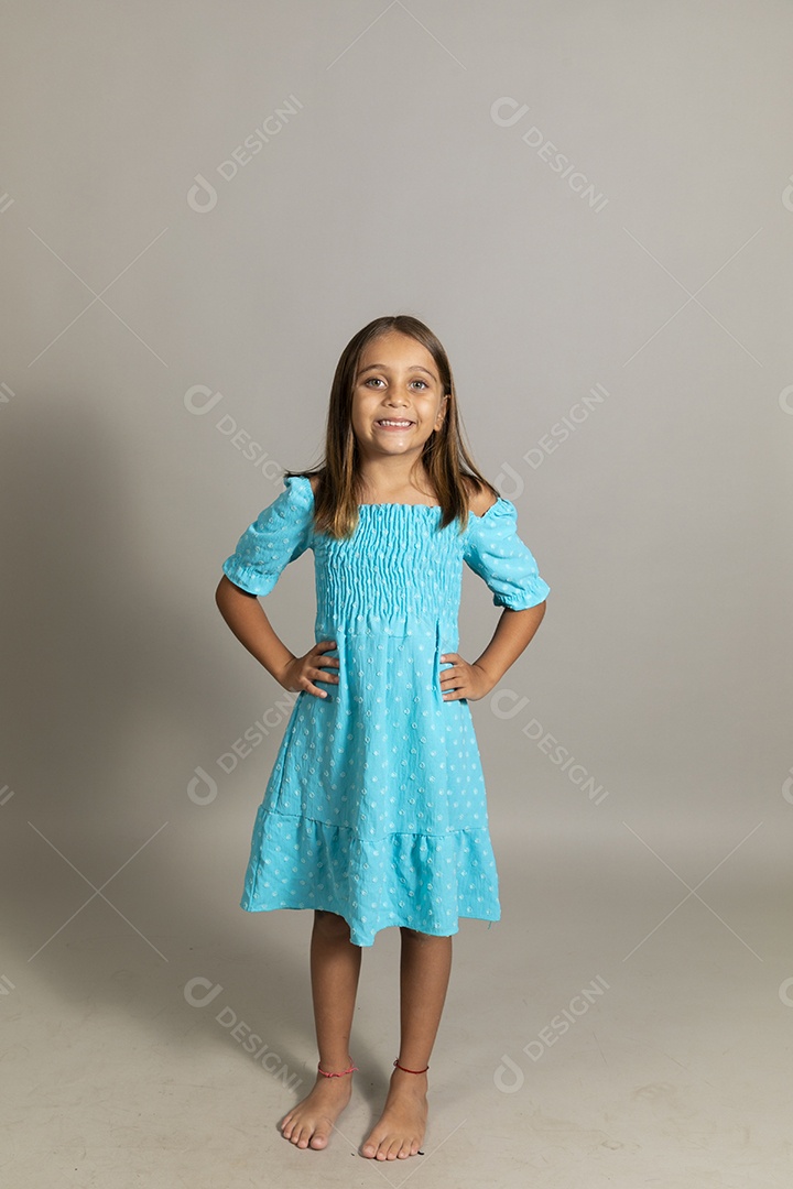 Linda garotinha usando vestido longo azul fazendo pose sobre fundo isolado