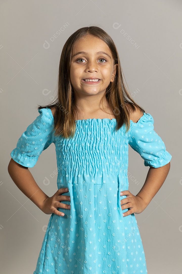 Linda garotinha usando vestido longo azul fazendo pose sobre fundo isolado