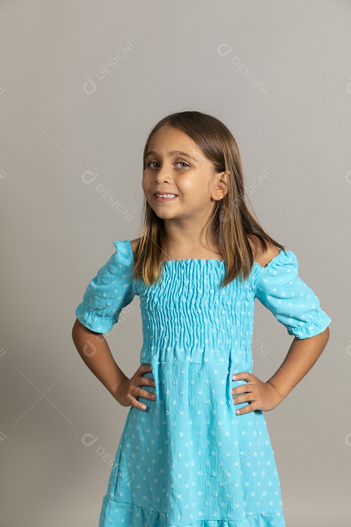 Linda garotinha usando vestido longo azul fazendo pose sobre fundo isolado