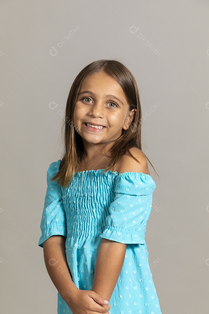 Linda garotinha usando vestido longo azul fazendo pose sobre fundo isolado