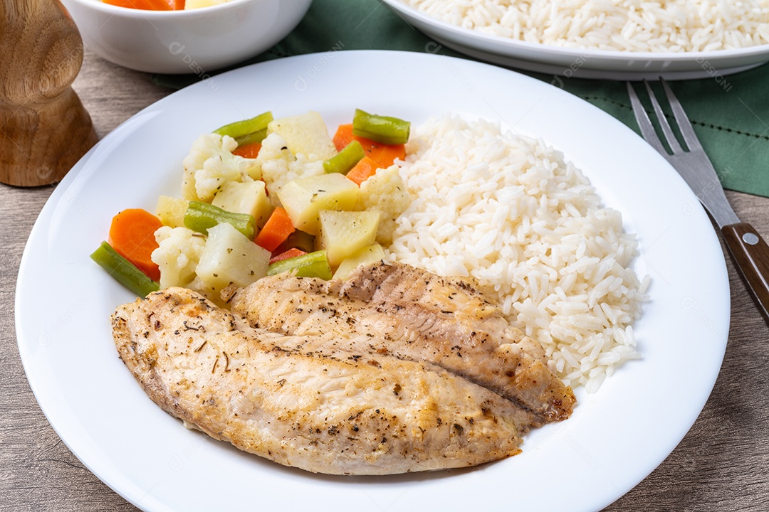A imagem mostra um prato com filé de peixe grelhado, arroz branco e vegetais cozidos.