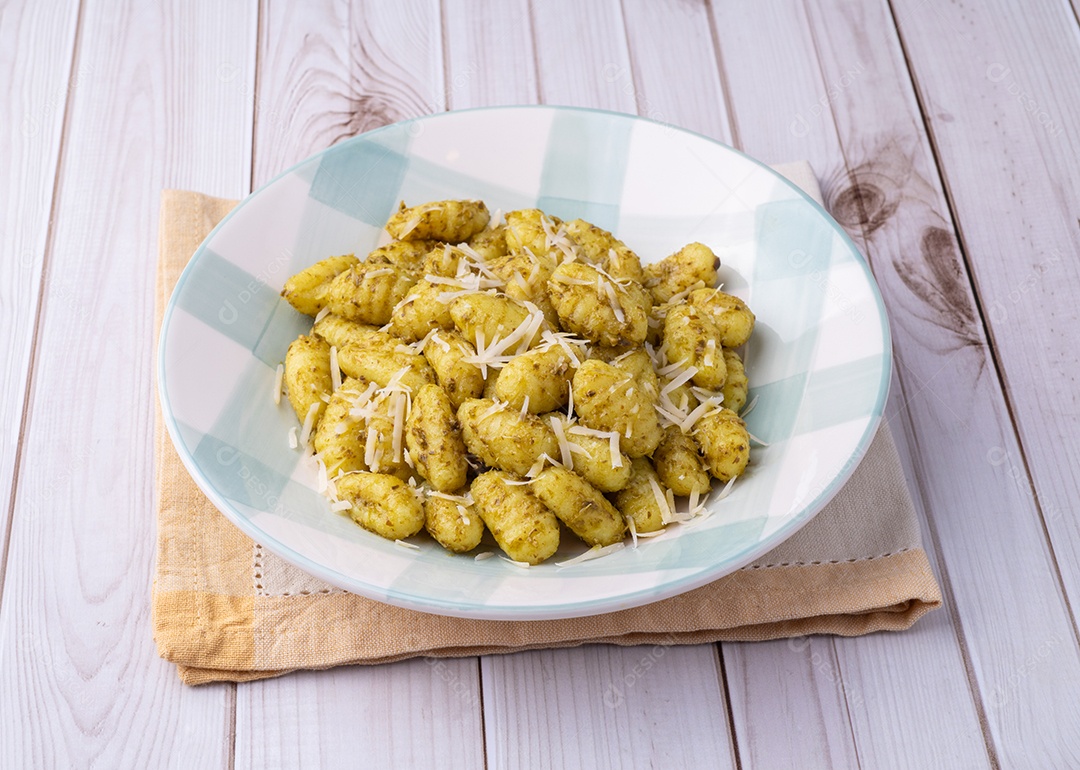 A imagem mostra um prato de nhoque (ou gnocchi, em italiano