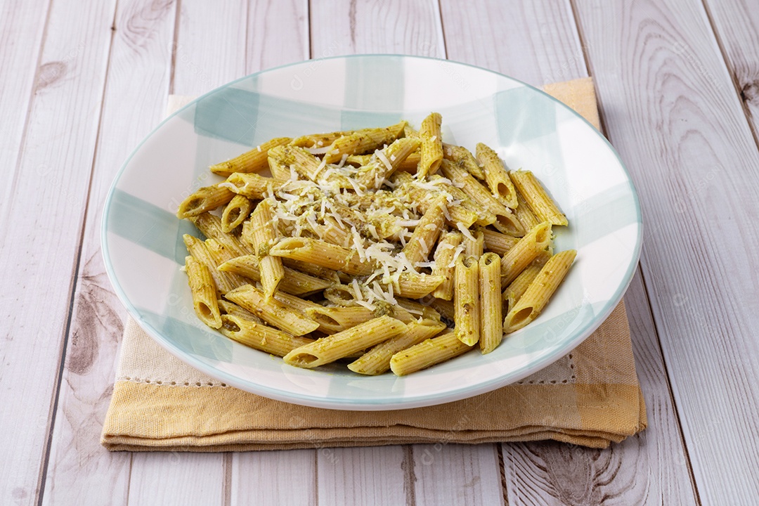 A imagem mostra um prato de Penne ao Molho Pesto