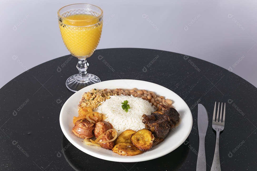 Bela refeição em um prato branco acompanhado pelo suco de laranja sobre mesa de madeira escura