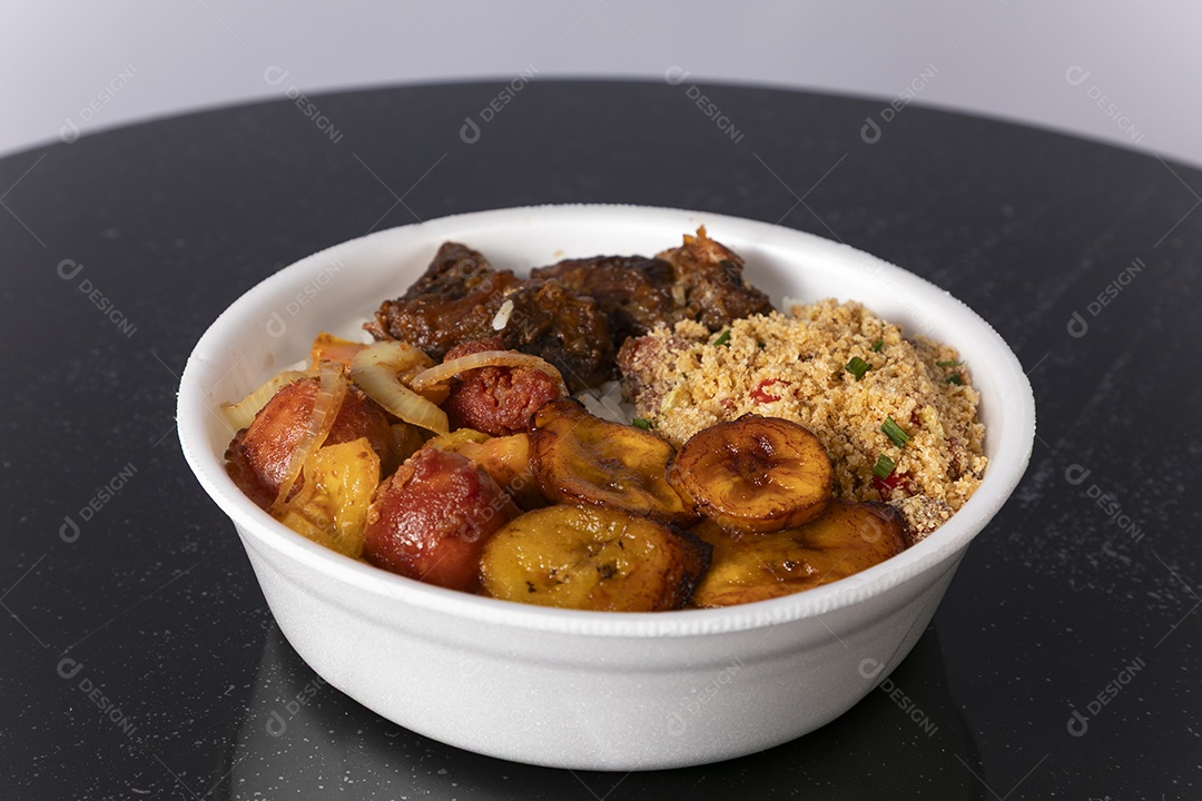 Bela refeição em uma marmitex branca sobre mesa de marmore escura