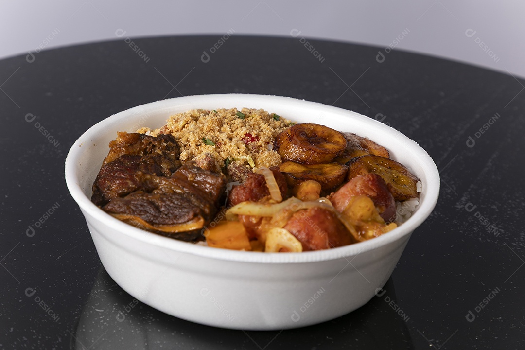 Bela refeição em uma marmitex branca sobre mesa de marmore escura