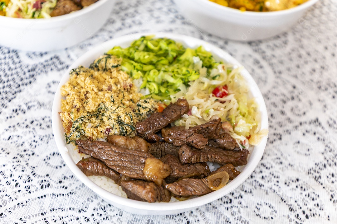 Belas refeições em marmitex branca sobre mesa de marmore escura