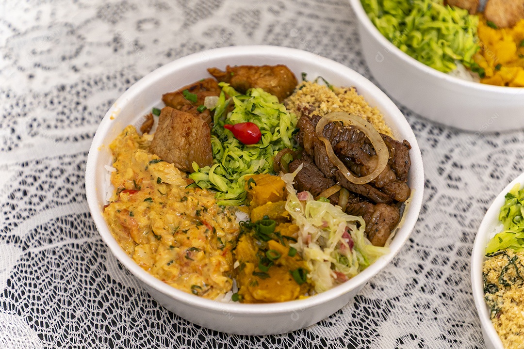 Belas refeições em marmitex branca sobre mesa de marmore escura