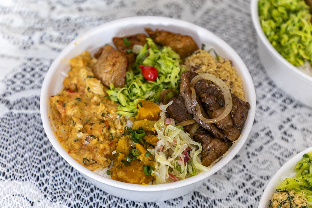 Belas refeições em marmitex branca sobre mesa de marmore escura