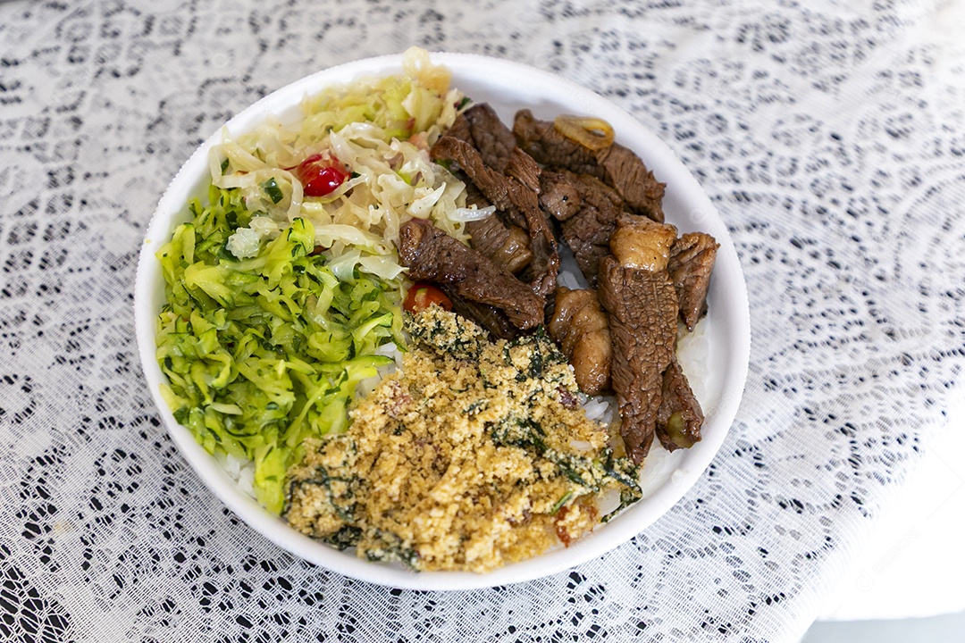 Bela refeição em uma marmitex branca sobre mesa de marmore escura