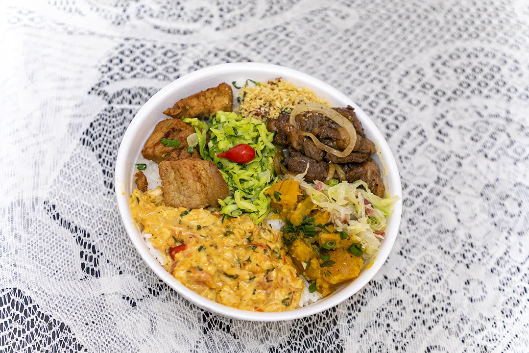 Bela refeição em uma marmitex branca sobre mesa de marmore escura