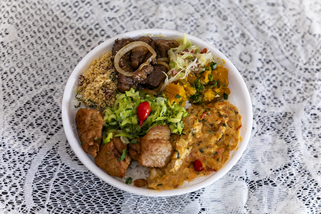 Bela refeição em uma marmitex branca sobre mesa de marmore escura