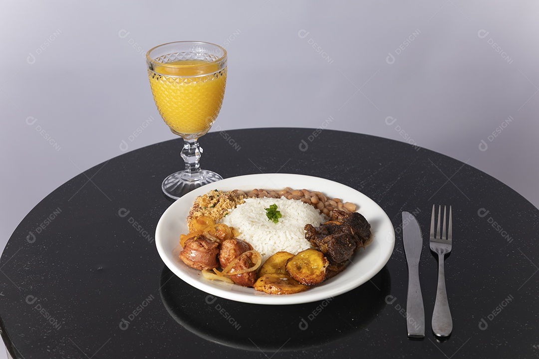Bela refeição em um prato branco acompanhado pelo suco de laranja sobre mesa de madeira escura