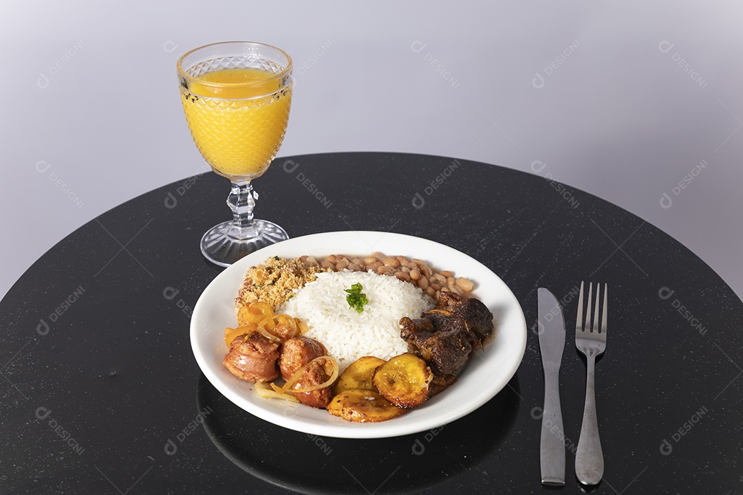 Bela refeição em um prato branco acompanhado pelo suco de laranja sobre mesa de madeira escura