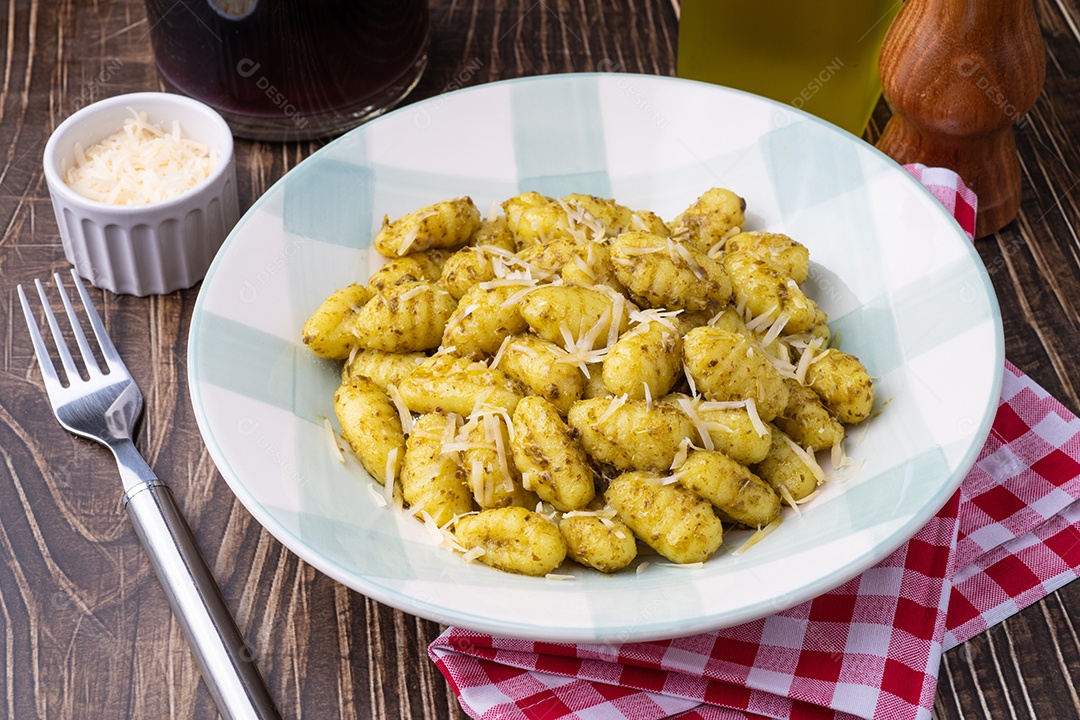 A imagem mostra um prato de nhoque com molho pesto.