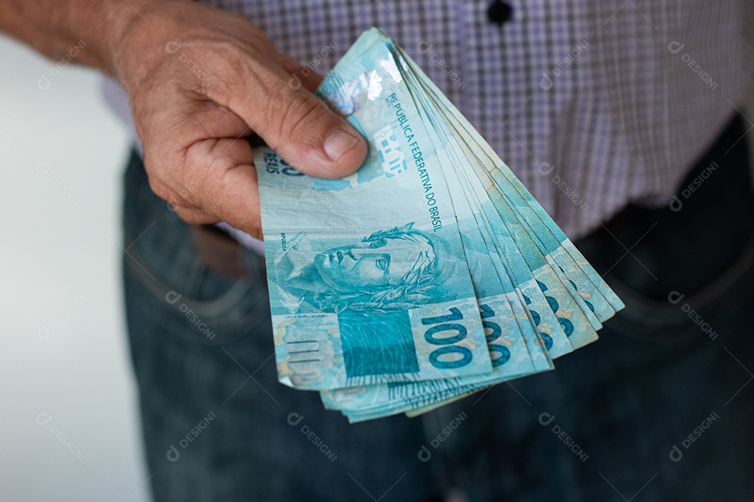 Homem segurando notas de real brasileiro e carteira