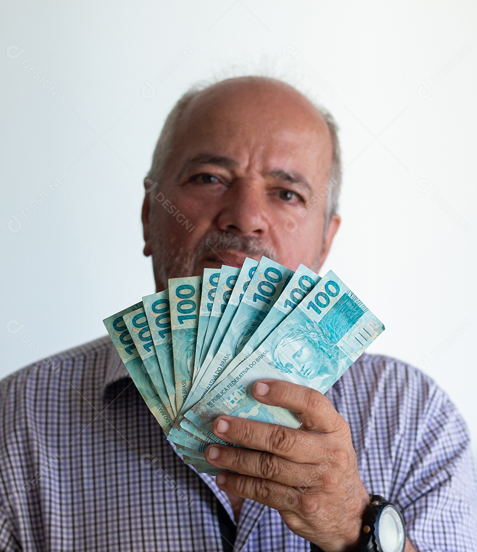 Homem segurando notas de real brasileiro na mão