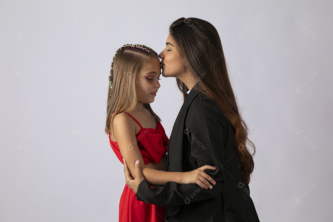 Bela mâe beijando testa de filha sobre fundo isolado