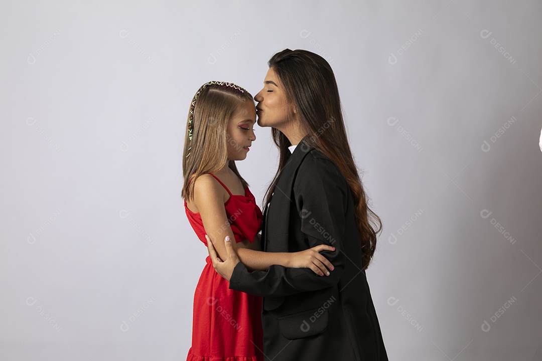Bela mãe beijando testa de filha sobre fundo isolado