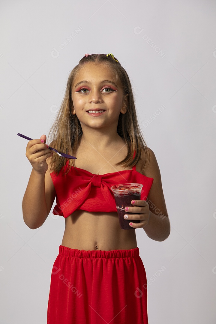 Linda menina com look vermelho segurando copo de açai sobre fundo de studio isolado