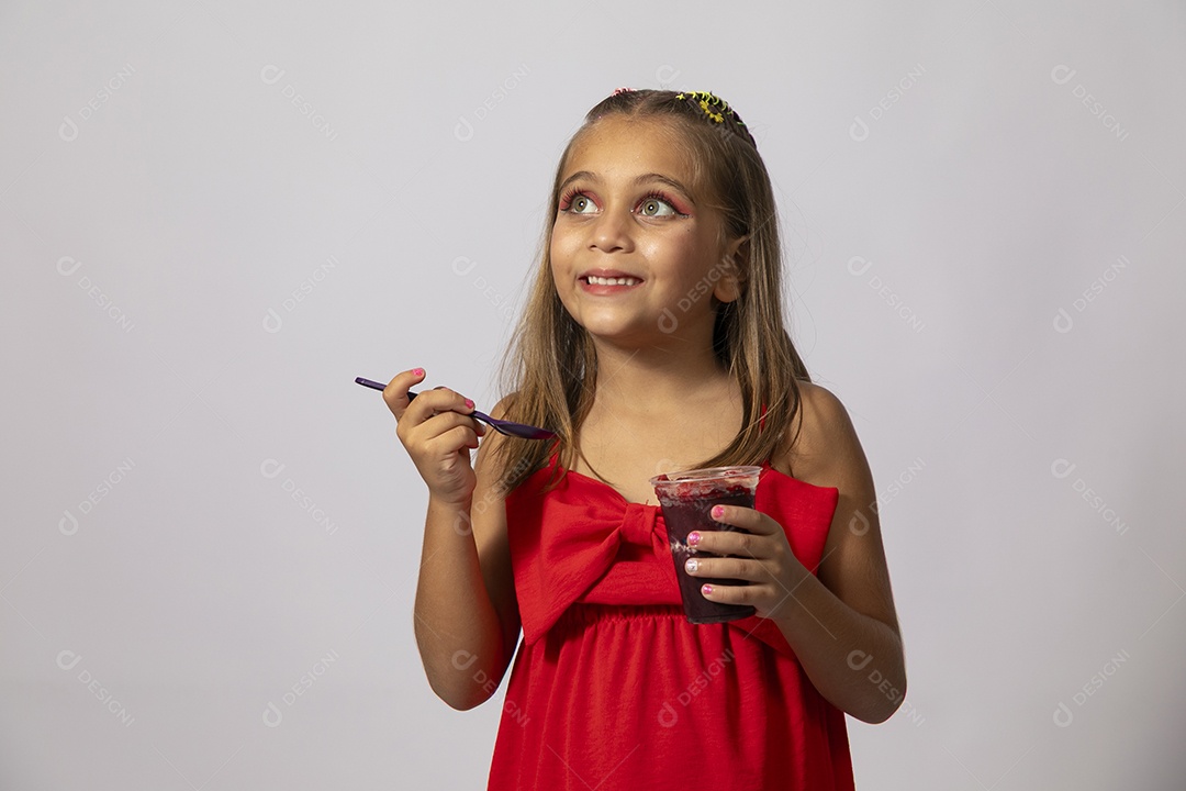Linda menina com look vermelho segurando copo de açai sobre fundo de studio isolado