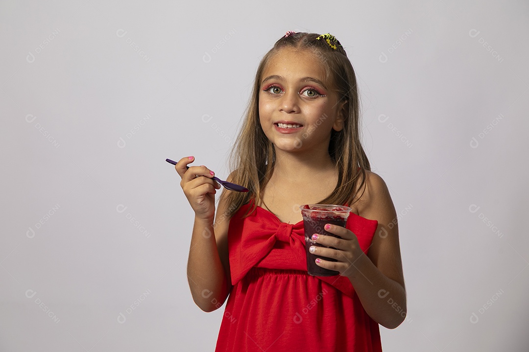 Linda menina com look vermelho segurando copo de açai sobre fundo de studio isolado