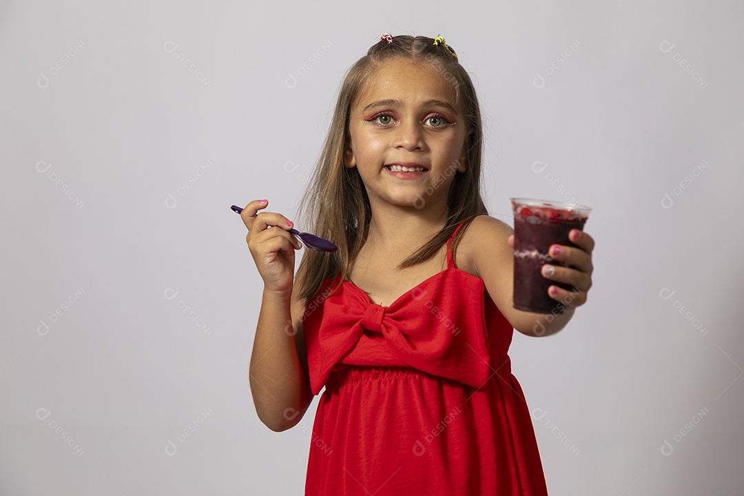 Linda menina com look vermelho segurando copo de açai sobre fundo de studio isolado